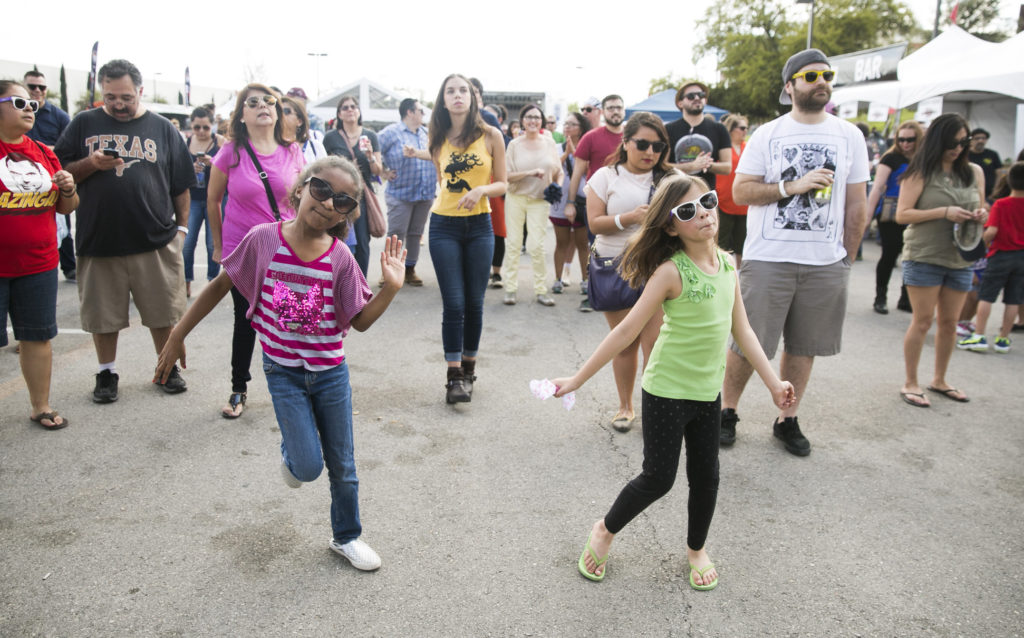 KELLY WEST / AMERICAN-STATESMAN Stephanie Bergara transforms herself into Selena for a performance with Bidi Bidi Banda at Rock the Lot in Austin, Texas on Saturday, March 14, 2015. Jordin Royster, 7, left, and Patti Collings, 8, dance to the music.